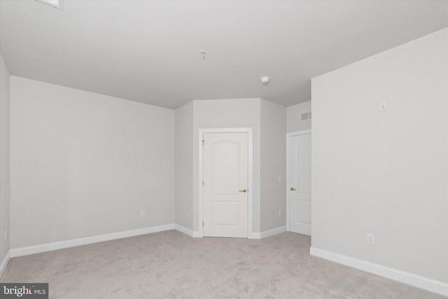 spare room featuring light colored carpet