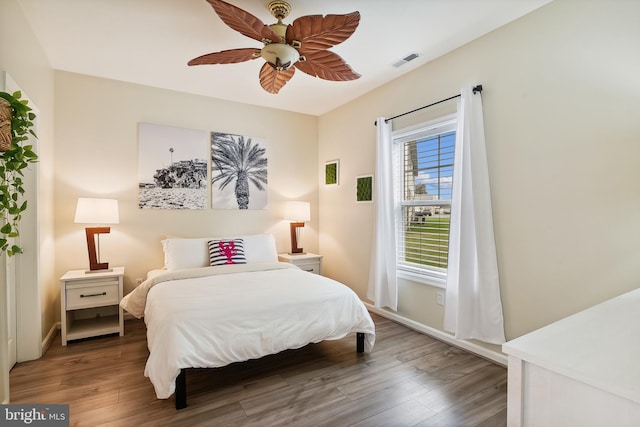 bedroom with dark hardwood / wood-style flooring and ceiling fan