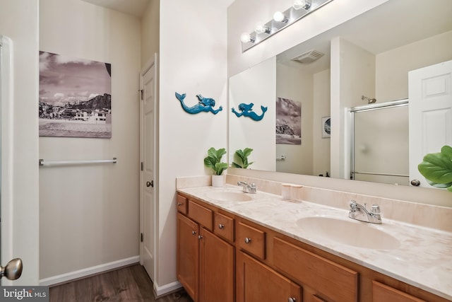 bathroom with vanity, wood-type flooring, and a shower with shower door