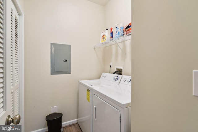 washroom featuring independent washer and dryer, electric panel, and wood-type flooring