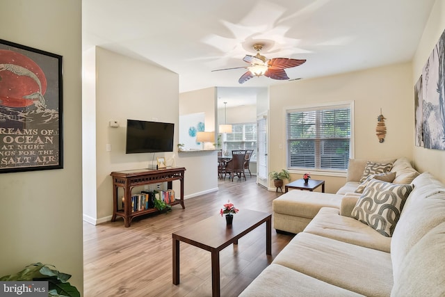 living room featuring light wood-type flooring and ceiling fan