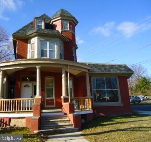 victorian house with covered porch and a front yard