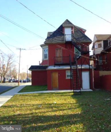 rear view of property featuring a lawn