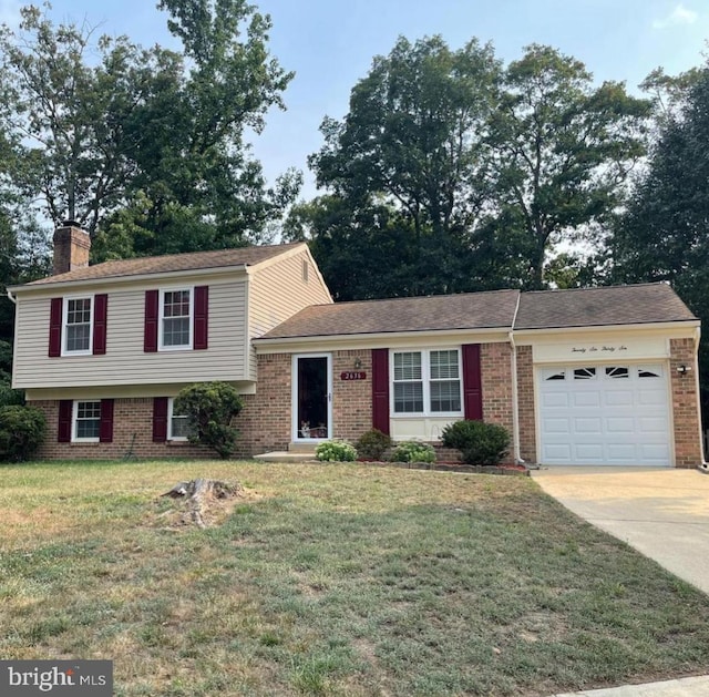 tri-level home with a garage and a front lawn