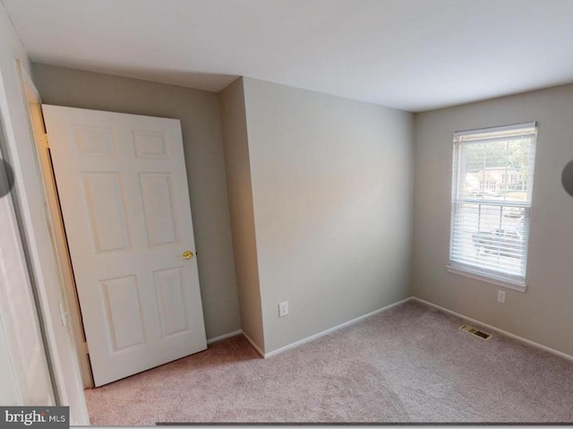 unfurnished room featuring light carpet