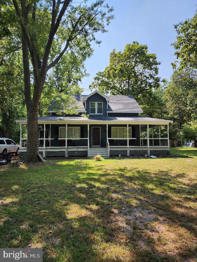 farmhouse-style home featuring a front lawn, a sunroom, and covered porch