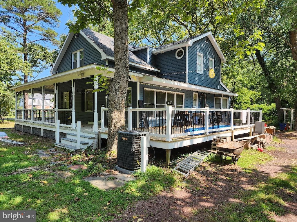 back of property with central AC unit and a wooden deck