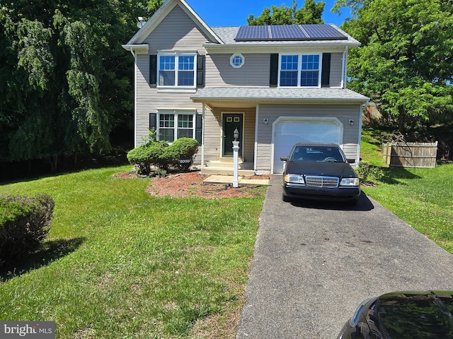 view of front of home with a front lawn, a garage, and solar panels