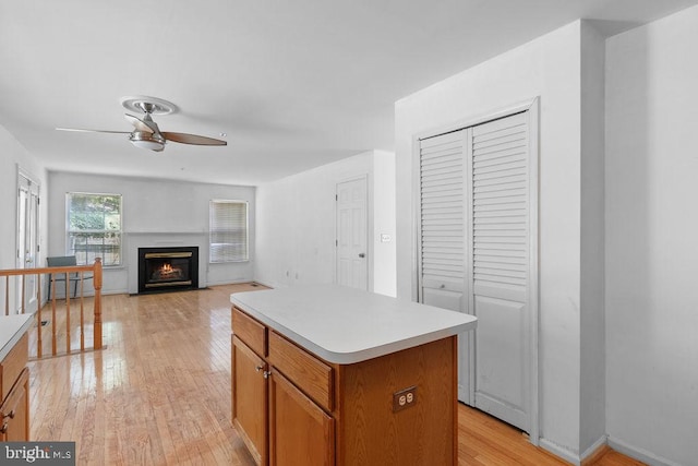 kitchen featuring ceiling fan, light wood-type flooring, and a kitchen island