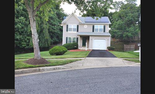 view of front of home featuring a garage, solar panels, and a front yard