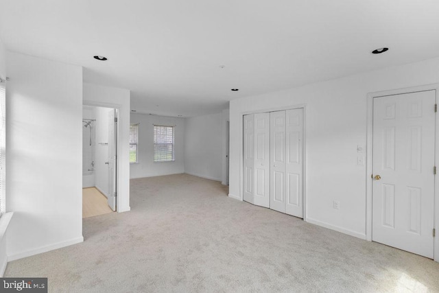 interior space featuring light carpet and ensuite bathroom