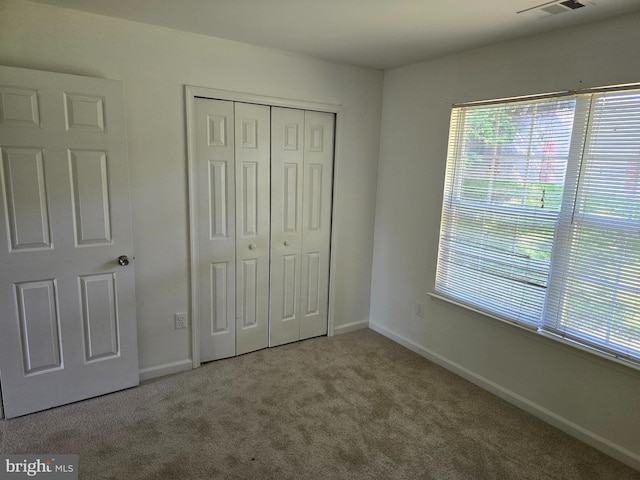 unfurnished bedroom with a closet and carpet flooring