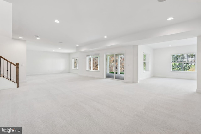 unfurnished living room with plenty of natural light and light colored carpet