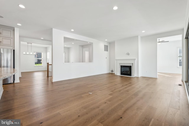 unfurnished living room featuring hardwood / wood-style flooring and ceiling fan