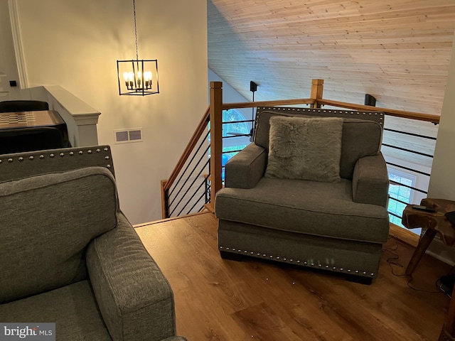 living area featuring a notable chandelier, vaulted ceiling, wood-type flooring, and wooden ceiling