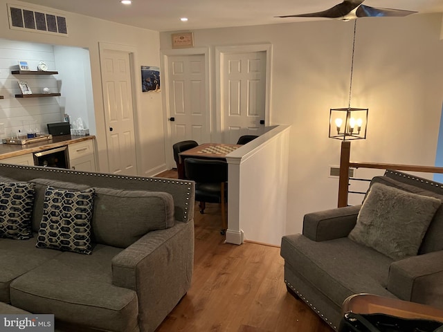 living room featuring light hardwood / wood-style flooring, beverage cooler, and a notable chandelier