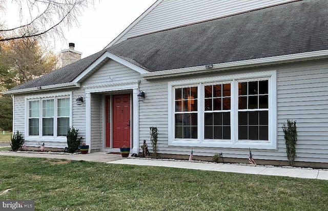 property entrance featuring a lawn