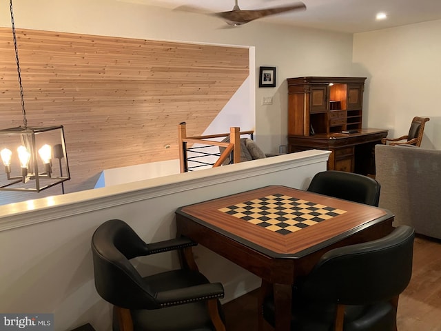 dining room with wood-type flooring, a notable chandelier, and wood walls