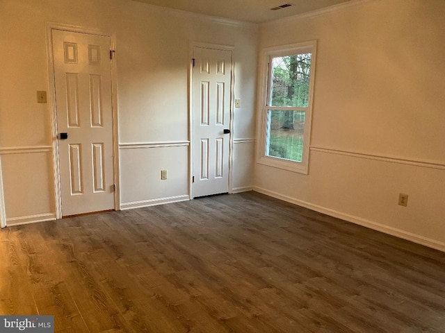 empty room featuring dark hardwood / wood-style floors and ornamental molding