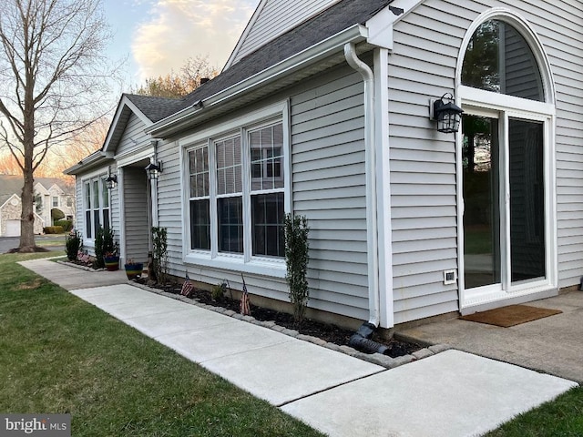 property exterior at dusk with a lawn