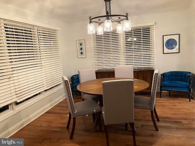 dining space with a notable chandelier and dark hardwood / wood-style flooring