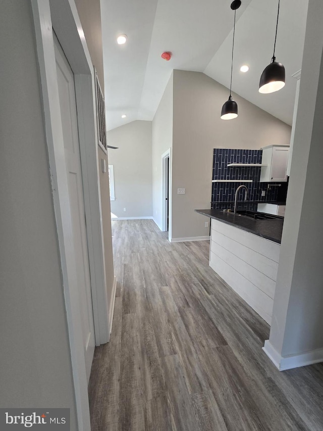 kitchen with white cabinetry, lofted ceiling, dark hardwood / wood-style floors, and decorative light fixtures