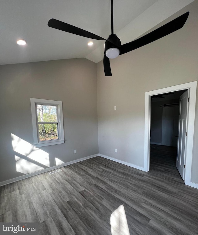 unfurnished room with ceiling fan, vaulted ceiling, and dark hardwood / wood-style floors