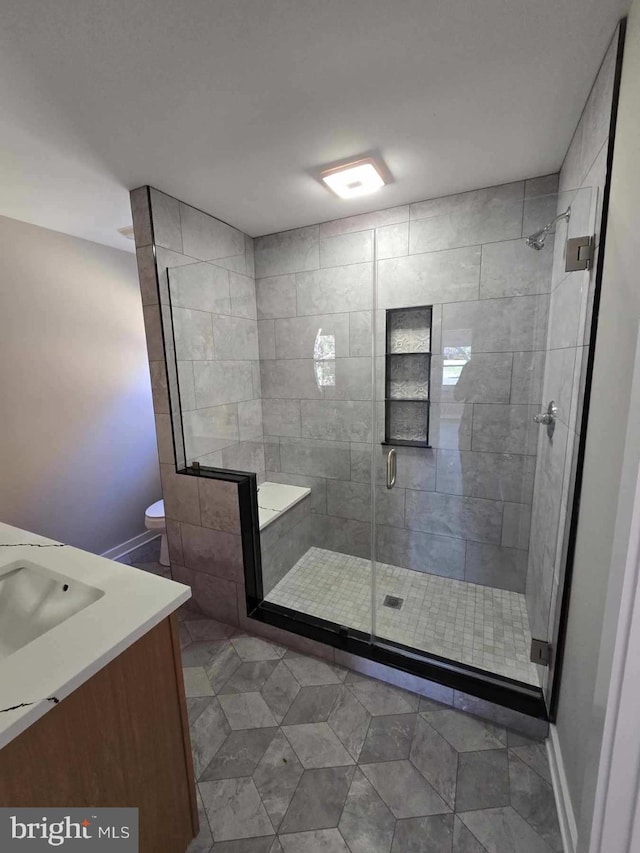 bathroom featuring walk in shower, tile patterned flooring, and vanity