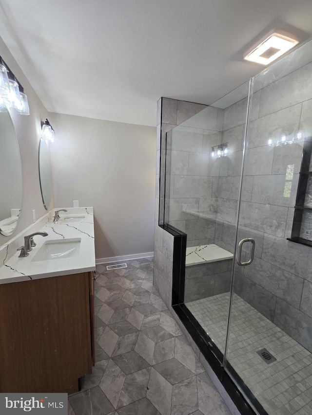 bathroom with vanity and a shower with door