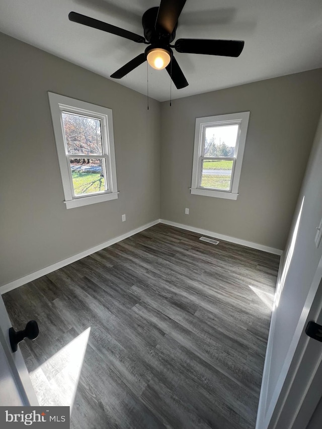 unfurnished room with ceiling fan and dark hardwood / wood-style floors