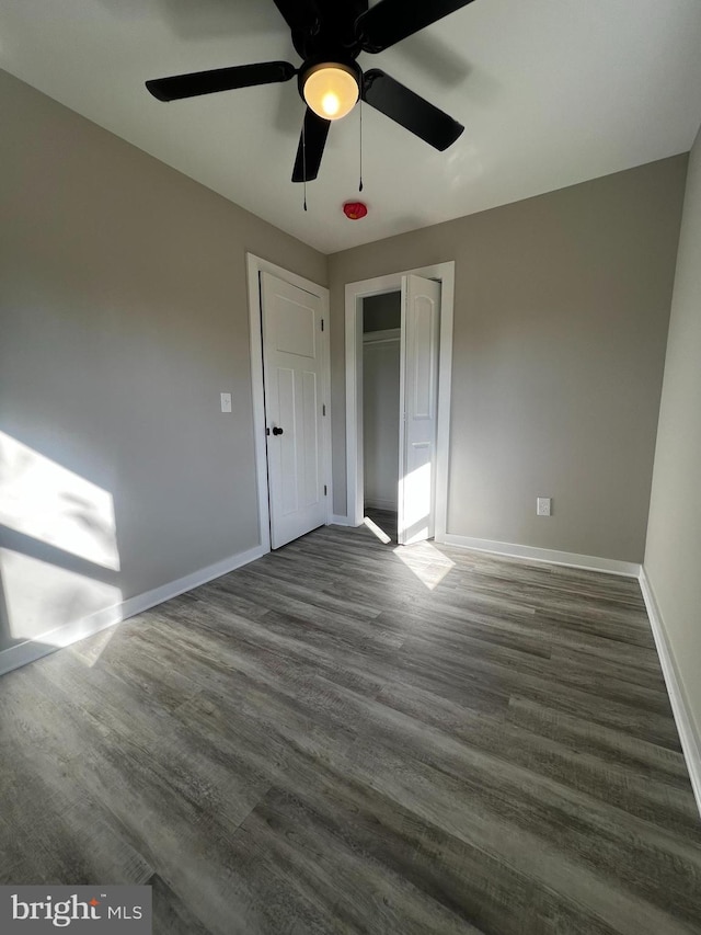 unfurnished bedroom featuring dark hardwood / wood-style flooring, a closet, and ceiling fan