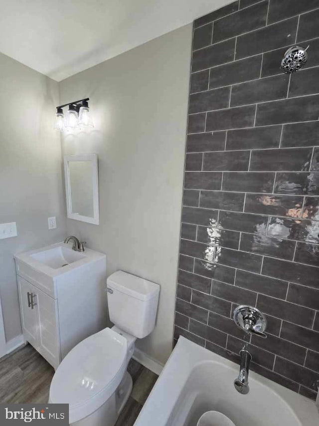 full bathroom with toilet, tiled shower / bath combo, vanity, and wood-type flooring