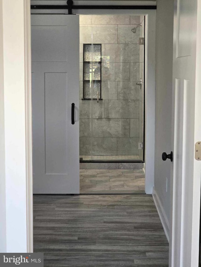 bathroom featuring hardwood / wood-style floors and a shower with door