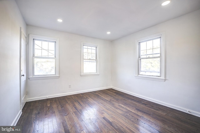 unfurnished room with dark wood-type flooring