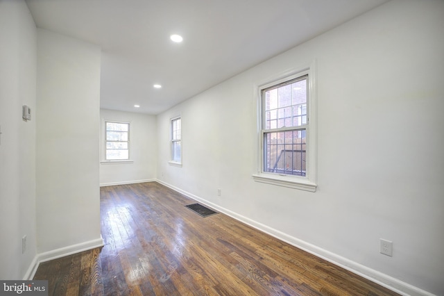 empty room with dark hardwood / wood-style flooring