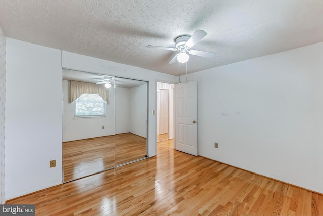 unfurnished bedroom featuring hardwood / wood-style floors, ceiling fan, a textured ceiling, and a closet