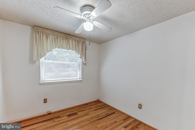 unfurnished room featuring hardwood / wood-style floors, ceiling fan, and a textured ceiling