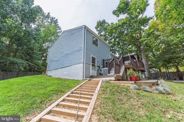 view of front facade featuring central AC unit, a front yard, and a deck