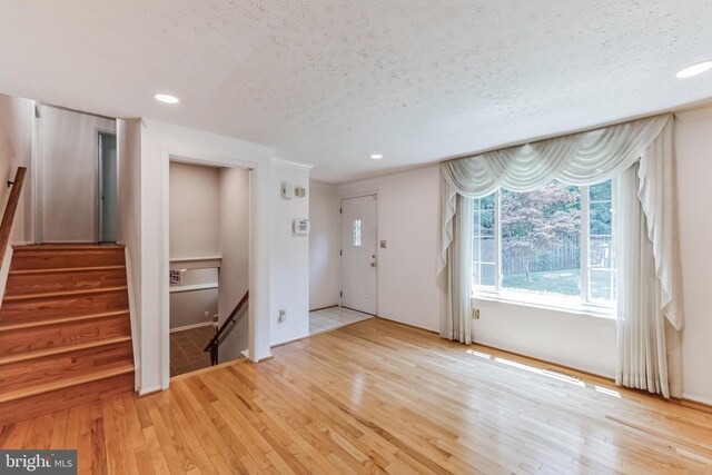 foyer featuring a textured ceiling and light hardwood / wood-style floors