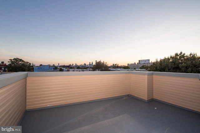 patio terrace at dusk featuring a balcony