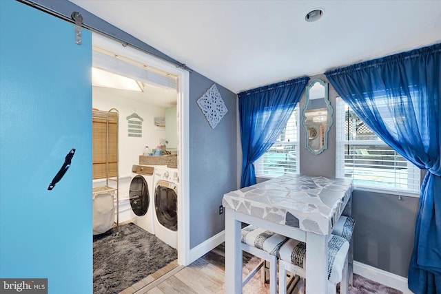 laundry room with hardwood / wood-style floors, a barn door, and separate washer and dryer