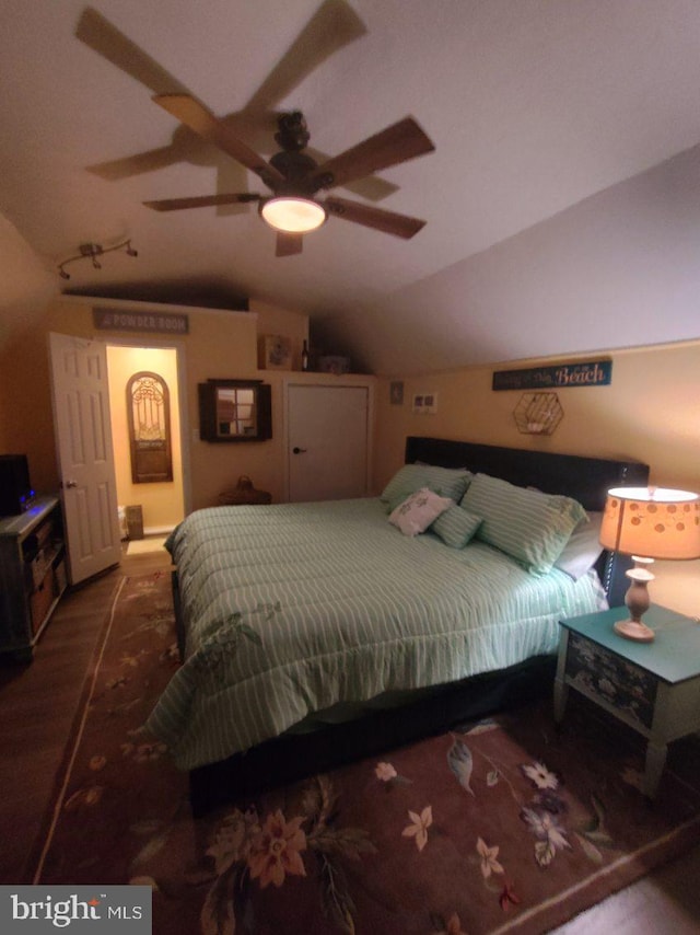 bedroom featuring ceiling fan, hardwood / wood-style floors, and vaulted ceiling