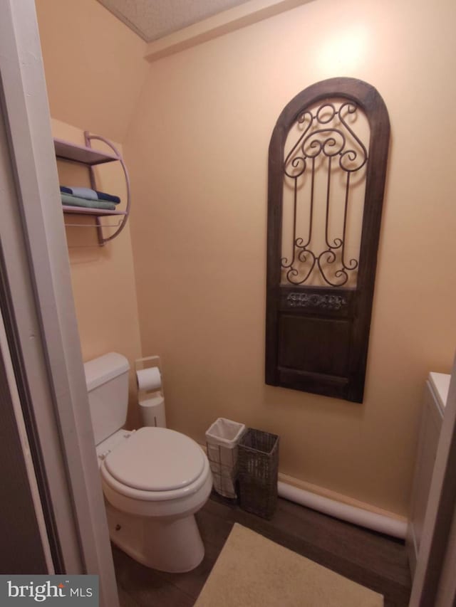 bathroom featuring hardwood / wood-style flooring, toilet, and a textured ceiling