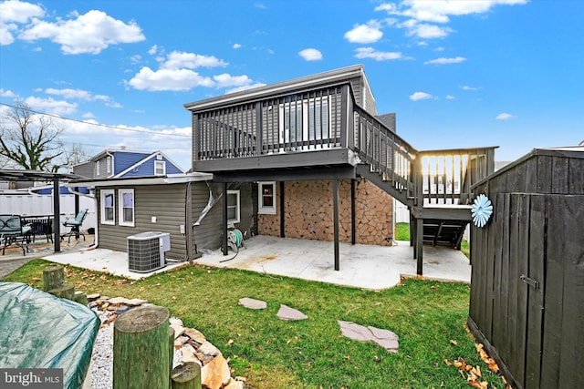 back of property featuring a lawn, cooling unit, a patio area, and a wooden deck