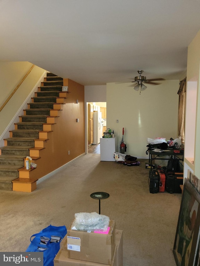 carpeted living room with ceiling fan