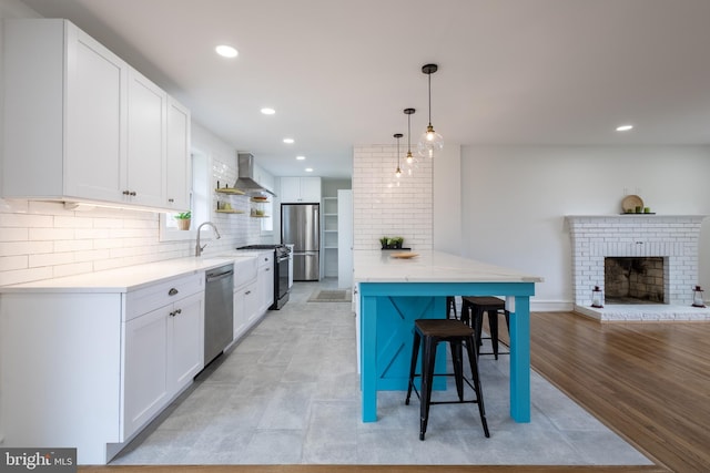 kitchen featuring hanging light fixtures, white cabinets, stainless steel appliances, and light hardwood / wood-style floors