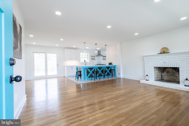 unfurnished living room featuring light wood-type flooring and a fireplace