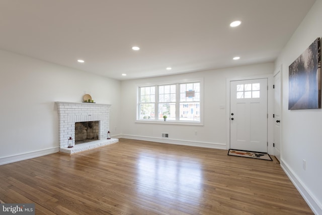 unfurnished living room with hardwood / wood-style flooring, a fireplace, and a wealth of natural light