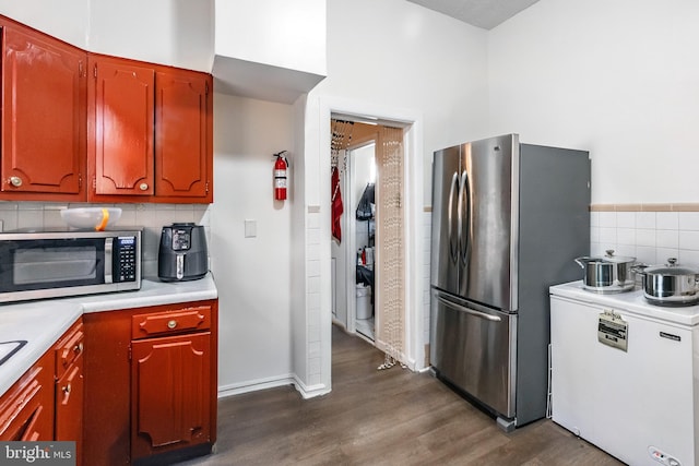 kitchen featuring backsplash, dark wood-type flooring, and appliances with stainless steel finishes