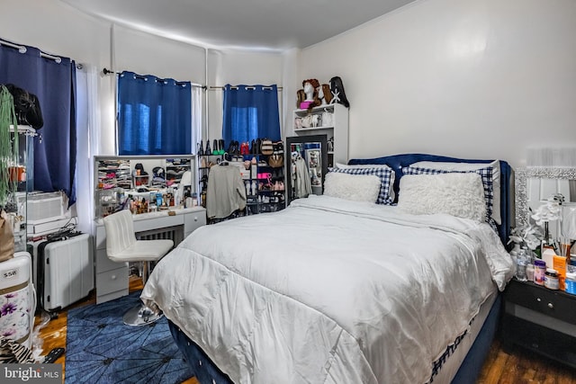 bedroom featuring dark hardwood / wood-style flooring and radiator